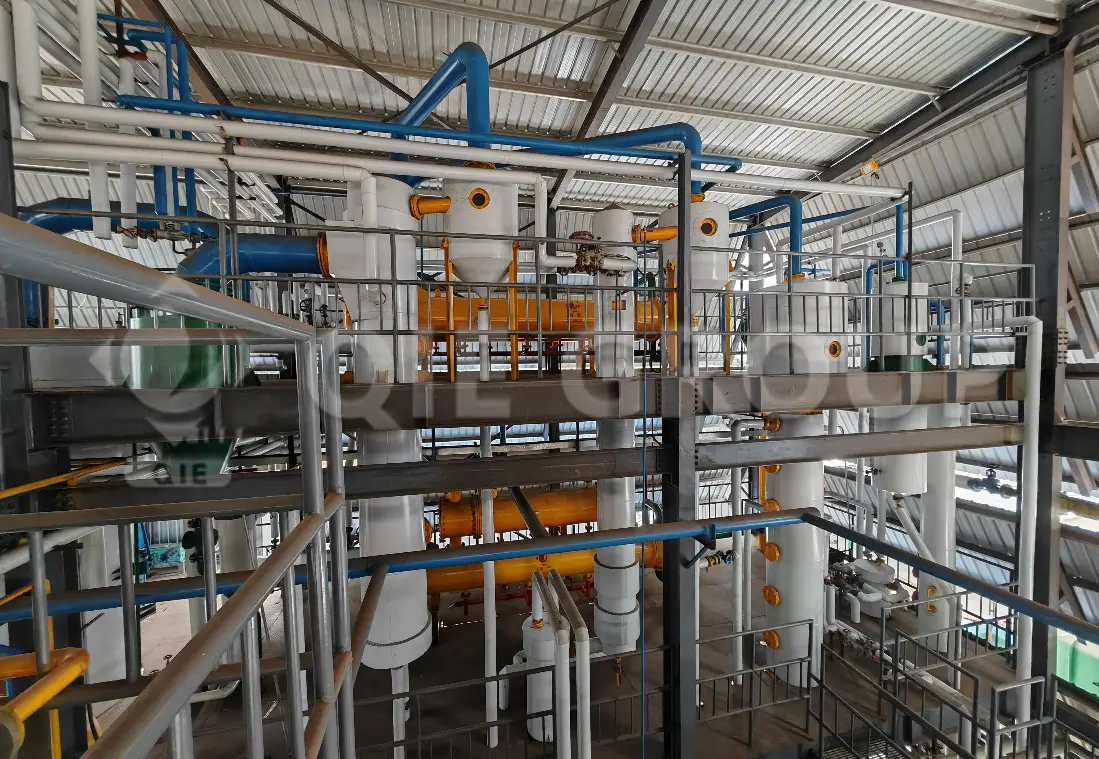 Taller de extracción de aceite de copra que muestra el extractor de cadena de arrastre y el sistema de extracción por disolventes.